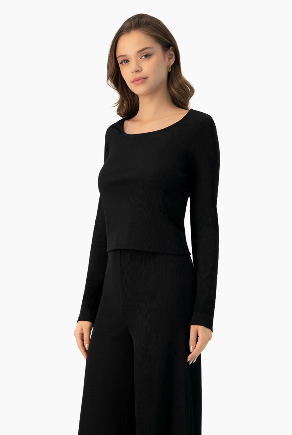 Top corto negro de manga larga y escote redondo, estilo casual.